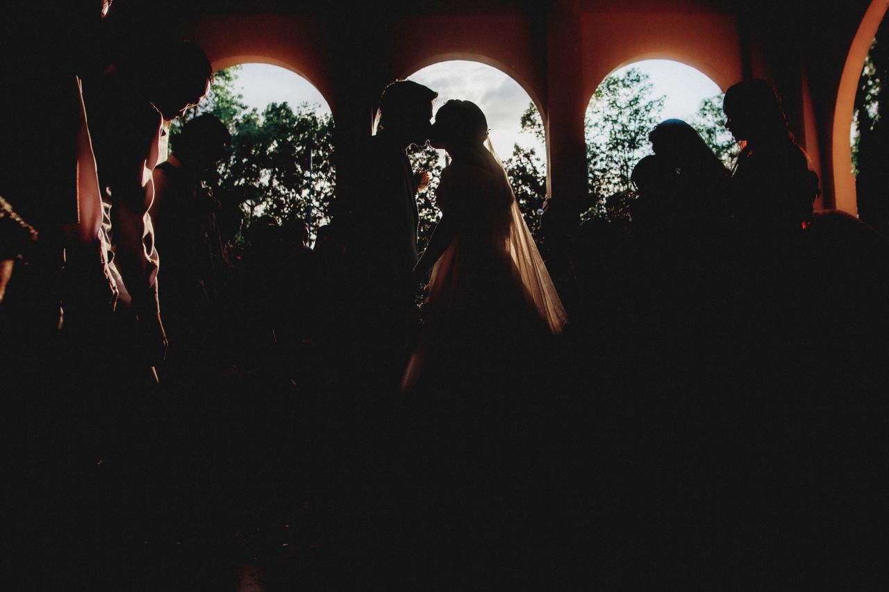 The Art of Drawing Readers In: Your attractive post title goes here Silhouette of newlyweds kissing in a dramatic wedding ceremony setting.